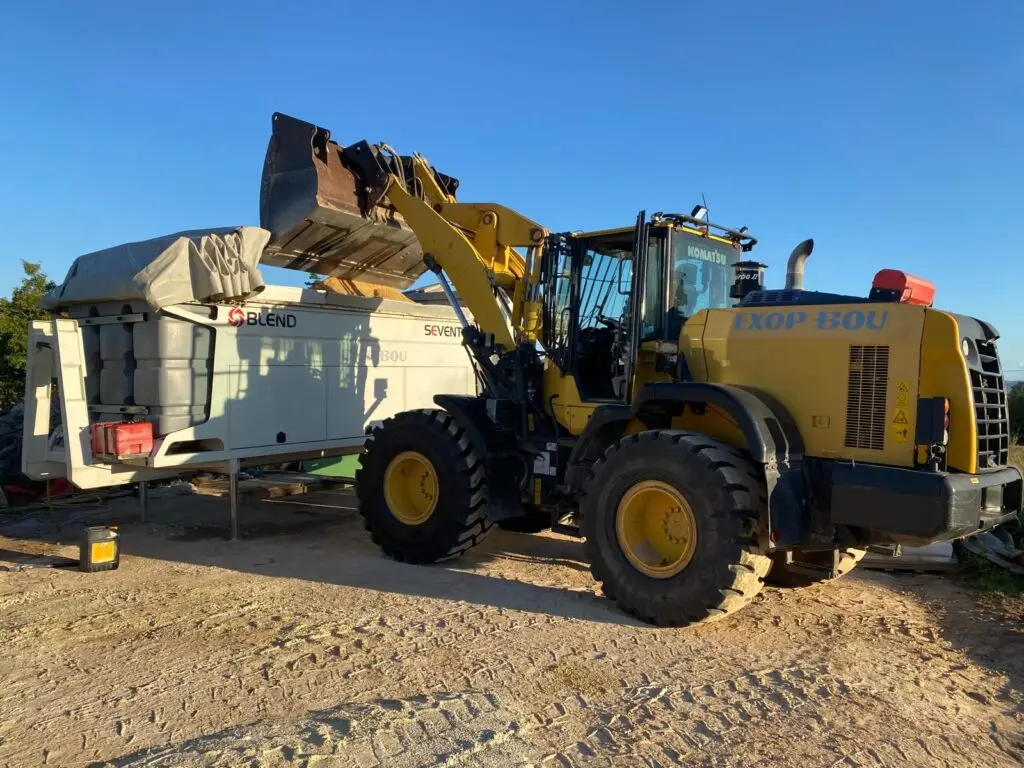 Equipo de mezcla empleado por EXOPBOU para ejecutar pavimentos naturales con control de peso de áridos, aporte de agua y dosificación precisa de materiales.